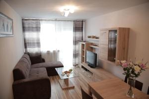 a living room with a couch and a tv at Premium Key-Apartaments Śródmieście in Warsaw