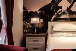 1 dormitorio con cama y mesita de noche con lámpara en Jean de Valette Boutique Living, en La Valeta