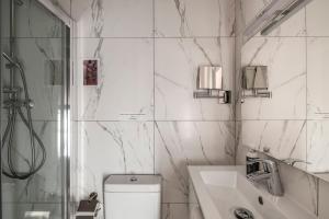 a bathroom with a toilet and a sink and a shower at Jean de Valette Boutique Living in Valletta