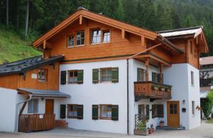 een groot wit gebouw met een houten dak bij Haus Holzeck in Schönau am Königssee