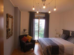 a bedroom with a bed and a chair and a window at Quarto di Luna in Genoa
