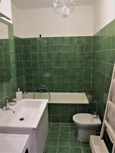 Baño de azulejos verdes con lavabo y aseo en Quarto di Luna en Génova