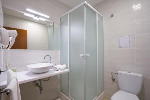 ein Badezimmer mit Waschbecken, Toilette und Spiegel in der Unterkunft Dixon Resort & Wellness in Banská Bystrica + 26 Fotos