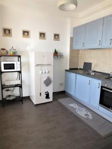 a kitchen with blue cabinets and a white refrigerator at Quarto di Luna in Genoa