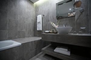 a bathroom with a sink and a mirror and a tub at Royal Tulip Achrafieh in Beirut