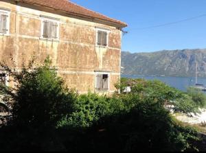 um antigo edifício de tijolos com vista para a água em Apartments Vila Marija em Kotor