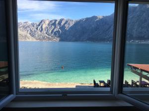 a view of a beach from a window at Apartments Vila Marija in Kotor