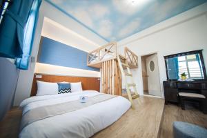 馬公市的住宿－起點旅行，一间卧室设有一张床、梯子和一张书桌