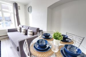a dining room with a table with blue dishes on it at Clarence Place in Edgware
