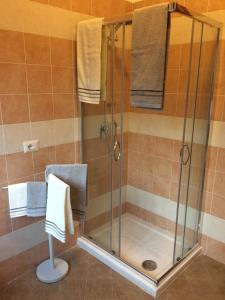 ducha con puerta de cristal y toallas en Casa Maruca, en Gassino Torinese