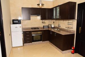 a kitchen with brown cabinets and a white refrigerator at Wellness Home in Tangier