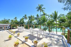 a balcony with white chairs and a view of the ocean at Signature Boracay South Beach in Boracay