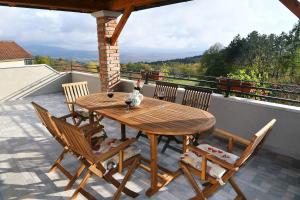 a wooden table and chairs on a balcony at Holiday Home Ivana in Pasjak