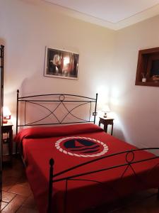 a bedroom with a bed with a red blanket at La Piccola Toscana 2 in Peccioli