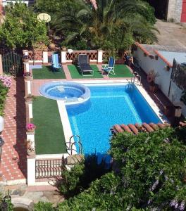 a swimming pool in a yard next to a house at Casa Rural Valdevilano in La Roca de la Sierra