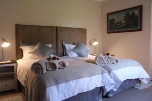 twee bedden in een hotelkamer met handdoeken erop bij Kismet Farm in Muldersdrift