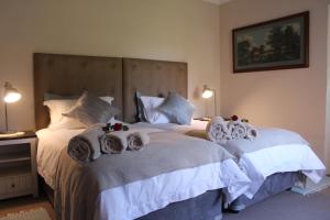 two beds in a hotel room with towels on them at Kismet Farm in Muldersdrift