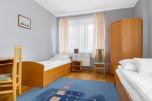 1 dormitorio con 2 camas, escritorio y ventana en Apartamenty Zielony przy MTP, en Poznan