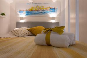 a bed with a pile of towels with a bow on it at Little House in Siracusa