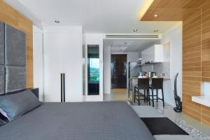 a bedroom with a large bed and a kitchen at Emerald Terrace Resort in Patong Beach