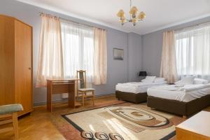 Sala de estar con 2 camas y mesa en Apartamenty Zielony przy MTP, en Poznan