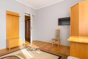 a living room with a tv and a chair at Apartamenty Zielony przy MTP in Poznań