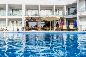 a hotel swimming pool with chairs and umbrellas at Bellini Hotel in Ayia Napa