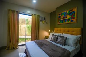 una camera da letto con un letto grande e una finestra di ETT HomeTel a Kalibo Altre 38 foto