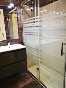 a bathroom with a glass shower and a sink at Sintra Design Apartment in Sintra