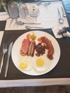 a plate of food with eggs and sausage on a table at Royl Court Guesthouse in Kimberley