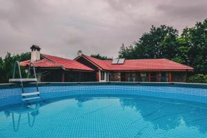 ein Haus mit einem Pool vor einem Haus in der Unterkunft Завоя in Krushuna