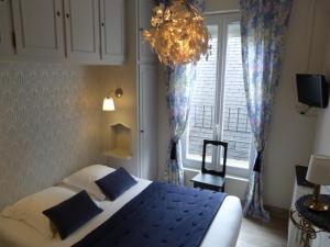 een slaapkamer met een bed met blauwe lakens en een raam bij Hôtel Le Bretagne in Vannes