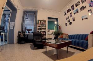 ナポリにある6 Small Roomsのリビングルーム(青いソファ、テーブル付)