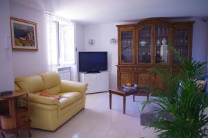 - un salon avec un canapé jaune et une télévision dans l'établissement Cà Marcon, à Castelnuovo Magra