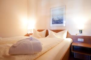 a bedroom with a bed with white sheets and pillows at Inselresidenz Strandburg Juist Woh in Juist