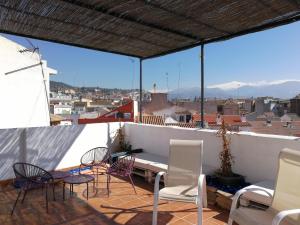 a patio with chairs and a table on a roof at Casa Montalbán Apartamentos Turísticos in Granada