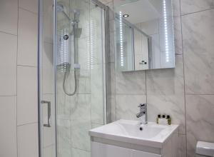 a white bathroom with a sink and a shower at Soho Suites by Indigo Flats in London