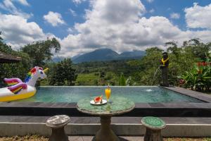 a small pool with a table and a unicorn next to it at Pondok Nyoman in Bedugul