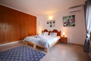 a bedroom with a bed and a blue rug at Villa Susan Ibiza in San Antonio +14 photos