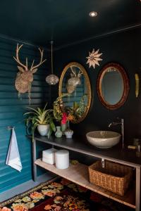 a bathroom with two mirrors and a sink at Woodcutters Forest Cottages in Knysna