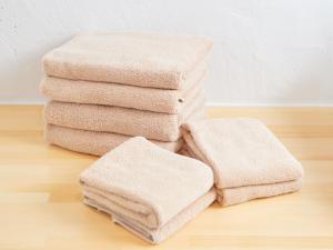 a stack of towels sitting on a wooden floor at ADAN RESORT 太陽 - Tida - in Bise