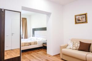 a bedroom with a bed and a mirror and a couch at Appartamento la Ninfea in Florence