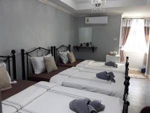 1 dormitorio con 3 camas y lámpara de araña en Sky cottage en Ko Samed