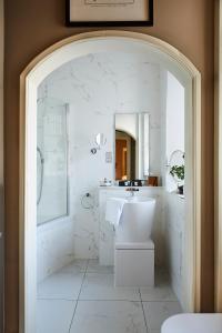 uma casa de banho branca com um chuveiro e um lavatório. em Cairn Lodge em Auchterarder