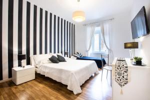1 dormitorio con cama y pared a rayas en blanco y negro en Rione Monti Suites, en Roma