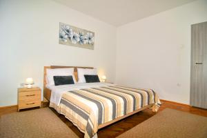 a bedroom with a bed and a dresser with two lamps at Apartman Nina in Zadar