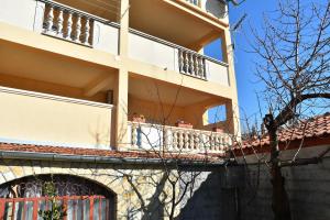 an apartment building with a balcony and a tree at Apartman Nina in Zadar