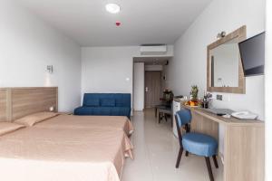 a bedroom with a bed and a desk with a mirror at Bellini Hotel in Ayia Napa