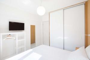 een witte slaapkamer met een glazen schuifdeur bij Seaview Luxurious Apartment near Corfu town by Konnect - Adults only in Corfu-stad