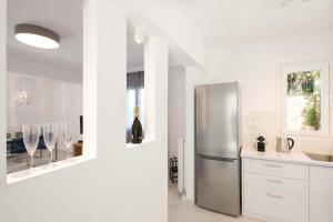 een keuken met een roestvrijstalen koelkast en wijnglazen bij Seaview Luxurious Apartment near Corfu town by Konnect - Adults only in Corfu-stad
